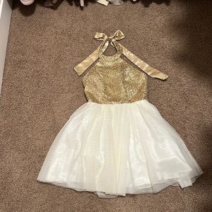 Sparkly gold halter dress with white tile and a ribbon bow in the back